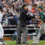 Home plate umpire Gary Darling, center, stands between Detroit Tigers designated hitter Victor Martinez, left, and Oakland Athletics relief pitcher Grant Balfour during the ninth inning of Game 3 of an American League baseball division series in Detroit, Monday, Oct. 7, 2013. (AP Photo/Paul Sancya)
