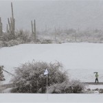 Spectators make their way off the course during a snow storm during the Match Play Championship golf tournament, Wednesday, Feb. 20, 2013, in Marana, Ariz. Play was suspended for the day. (AP Photo/Ted S. Warren)