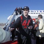 Stanford linebacker Chase Thomas, center, is greeted by Fiesta Bowl committee members upon arrival to play Oklahoma State in the Fiesta Bowl college football game Monday, Dec. 26, 2011at Sky Harbor International Airport in Phoenix. (AP Photo/Paul Connors)