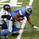 Detroit Lions wide receiver Calvin Johnson (81) is stopped by Baltimore Ravens cornerback Jimmy Smith (22) during the first half of an NFL football game in Detroit, Monday, Dec. 16, 2013. (AP Photo/Paul Sancya)