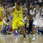 Michigan's Glenn Robinson III steals the ball from Kansas' Naadir Tharpe during overtime of a regional semifinal game in the NCAA college basketball tournament, Friday, March 29, 2013, in Arlington, Texas. (AP Photo/David J. Phillip)
