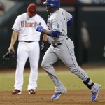 Los Angeles Dodgers' Juan Uribe, right, rounds the bases after hitting a two-run home run during the first inning of a baseball game as Arizona Diamondbacks' Eric Chavez looks down, Tuesday, Sept. 17, 2013, in Phoenix. (AP Photo/Matt York)