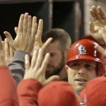 St. Louis Cardinals' Matt Holliday is congratulated in the dugout after scoring a run during the fifth inning of Game 4 of baseball's National League championship series against the San Francisco Giants Thursday, Oct. 18, 2012, in St. Louis. (AP Photo/David J. Phillip)