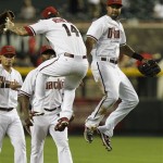 Arizona Diamondbacks' Ryan Roberts (14) and Chris Young, right, celebrate a win over the Pittsburgh Pirates as teammates Gerardo Parra, left, and Justin Upton look on after a baseball game Monday, April 16, 2012, in Phoenix. The Diamondbacks defeated the Pirates 5-1.(AP Photo/Ross D. Franklin)