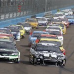 Pole winner Jimmie Johnson (48), right, and Denny Hamlin (11) lead the field into turn one during the first lap of the AdvoCare 500 NASCAR Sprint Cup Series auto race at Phoenix International Raceway, Sunday, Nov. 10, 2013 in Avondale, Ariz. (AP Photo/Ralph Freso)
