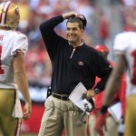 San Francisco 49ers head coach Jim Harbaugh grimaces after his offense fails to move the ball as Alex Smith (11) and Ted Ginn (19) come off the field during the second quarter in an NFL football game against the Arizona Cardinals, Sunday, Dec. 11, 2011, in Glendale, Ariz.(AP Photo/Ralph Freso)