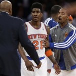 New York Knicks' Iman Shumpert, center, is restrained by J.R. Smith, right, and coach Mike Woodson during an argument with the Indiana Pacers in the first half of Game 5 of an Eastern Conference semifinal in the NBA basketball playoffs, at Madison Square Garden in New York, Thursday, May 16, 2013. (AP Photo/Julio Cortez)