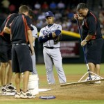 Tampa Bay Rays' Yunel Escobar watches the grounds crew fix the pitching mound during the fifth inning of the Rays' baseball game against the Arizona Diamondbacks, Wednesday, Aug. 7, 2013, in Phoenix. (AP Photo/Matt York)