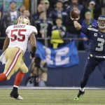  Seattle Seahawks' Russell Wilson throws during the first half of the NFL football NFC Championship game against the San Francisco 49ers Sunday, Jan. 19, 2014, in Seattle. (AP Photo/Elaine Thompson)
