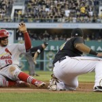 
St. Louis Cardinals' Jon Jay (19) safely steals third base on the front end of a double-steal as Pittsburgh Pirates third baseman Pedro Alvarez, right, applies a late tag in the fifth inning of of Game 3 of a National League division baseball series on Sunday, Oct. 6, 2013, in Pittsburgh. (AP Photo/Gene J. Puskar)