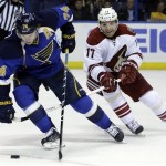 St. Louis Blues' T.J. Oshie, left, handles the puck as Phoenix Coyotes' Radim Vrbata, of the Czech Republic, defends during the second period of an NHL hockey game Tuesday, Jan. 14, 2014, in St. Louis. (AP Photo/Jeff Roberson)
