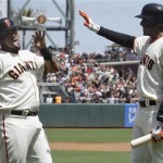 San Francisco Giants' Hector Sanchez, left, is congratulated by Joaquin Arias after scoring on Brandon Belt's triple against the Arizona Diamondbacks during the first inning of a baseball game in San Francisco, Monday, May 28, 2012. (AP Photo/Jeff Chiu)