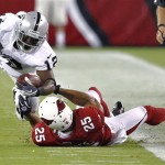 Oakland Raiders wide receiver Jacoby Ford (12) is tackled by Arizona Cardinals defensive back Kerry Rhodes (25) during the first half of a preseason NFL football game, Friday, Aug. 17, 2012, in Glendale, Ariz. (AP Photo/Matt York)