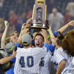 UCLA closing pitcher David Berg (26) stands in front of teammate Ryan Deeter (40) as Berg and other players hoist the championship trophy after UCLA defeated Mississippi State 8-0 in the second game of the NCAA College World Series baseball finals, Tuesday, June 25, 2013, in Omaha, Neb. (AP Photo/Ted Kirk)