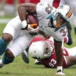 Miami Dolphins running back Daniel Thomas (33) is tripped up by Arizona Cardinals defensive end Calais Campbell during the first half of an NFL football game, Sunday, Sept. 30, 2012, in Glendale, Ariz. (AP Photo/Paul Connors)
