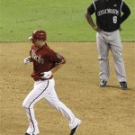 Arizona Diamondbacks' Adam LaRoche, left, rounds the bases after hitting a two-run home run as Colorado Rockies' Melvin Mora looks on during the third inning of a baseball game Wednesday, Sept. 22, 2010, in Phoenix. (AP Photo/Ross D. Franklin)