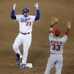 Los Angeles Dodgers' Adrian Gonzalez (23) reacts in front of St. Louis Cardinals' Daniel Descalso (33) after hitting a double during the fourth inning of Game 4 of the National League baseball championship series Tuesday, Oct. 15, 2013, in Los Angeles. (AP Photo/Jae C. Hong)