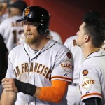 San Francisco Giants' Hunter Pence, left, walks past teammate Buster Posey, right, after Pence scored a run against the Arizona Diamondbacks during the second inning of a baseball game Friday, July 17, 2015, in Phoenix. (AP Photo/Ross D. Franklin)
