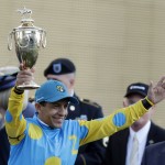 Victor Espinoza holds the trophy after riding American Pharoah to victory in the 141st running of the Kentucky Derby horse race at Churchill Downs Saturday, May 2, 2015, in Louisville, Ky. (AP Photo/Brynn Anderson)