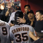 San Francisco Giants' Brandon Crawford (35) celebrates his run scored against the Arizona Diamondbacks with teammates, including Buster Posey, right, during the 12th inning of a baseball game Friday, July 17, 2015, in Phoenix. The Giants defeated the Diamondbacks 6-5. (AP Photo/Ross D. Franklin)
