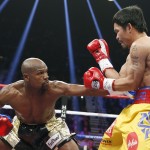 Floyd Mayweather Jr., left, connects with a left to the body of Manny Pacquiao, from the Philippines, during their welterweight title fight on Saturday, May 2, 2015 in Las Vegas. (AP Photo/John Locher)