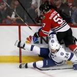 Chicago Blackhawks' Trevor van Riemsyk (57) and Tampa Bay Lightning's Ryan Callahan (24) get tangled up along the boards during the third period in Game 3 of the NHL hockey Stanley Cup Final on Monday, June 8, 2015, in Chicago. (AP Photo/Charles Rex Arbogast)