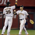 San Francisco Giants' Brandon Crawford (35) and Gregor Blanco celebrate after Game 1 of baseball's World Series against the Kansas City Royals Tuesday, Oct. 21, 2014, in Kansas City, Mo. The Giants won 7-1 to take a 1-0 lead in the series. (AP Photo/David J. Phillip)