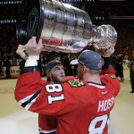 Chicago Blackhawks' Patrick Kane hands off the Stanley Cup Trophy to teammate Marian Hossa, of Slovakia, after defeating the Tampa Bay Lightning in Game 6 of the NHL hockey Stanley Cup Final series on Monday, June 15, 2015, in Chicago. The Blackhawks defeated the Lightning 2-0 to win the series 4-2. (AP Photo/Nam Y. Huh)
