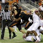 Oklahoma State quarterback J.W. Walsh rumbles past Florida State defenders into the end zone for a touchdown in the second half of an NCAA college football game, Saturday, Aug. 30, 2014, in Arlington, Texas. FSU won 37-31. (AP Photo/Tony Gutierrez)
