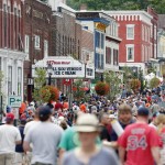 People walk along Main Street on Saturday, July 25, 2015, in Cooperstown, N.Y. The National Baseball Hall of Fame holds its induction ceremony on Sunday. (AP Photo/Mike Groll)
