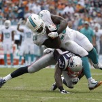 Miami Dolphins running back Lamar Miller (26) is tackled by New England Patriots strong safety Tavon Wilson (27), during the second half of an NFL football game, in Miami Gardens, Fla., Sunday Sept. 7, 2014. (AP PhotoLynne Sladky)