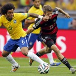 Brazil's Marcelo, left, and Germany's Thomas Mueller challenge for the ball during the World Cup semifinal soccer match between Brazil and Germany at the Mineirao Stadium in Belo Horizonte, Brazil, Tuesday, July 8, 2014. (AP Photo/Frank Augstein)
