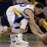 Cleveland Cavaliers guard Matthew Dellavedova, bottom, reaches for the ball under Golden State Warriors guard Stephen Curry during the first half of Game 5 of basketball's NBA Finals in Oakland, Calif., Sunday, June 14, 2015. (AP Photo/Ben Margot)
