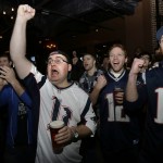 Joe Burke, of Boston, center left, raises his arm and cheers with other fans while watching the New England Patriots play against the Seattle Seahawks in the NFL Super Bowl XLIX football game in Glendale, Ariz., Sunday, Feb. 1, 2015, at a bar in Boston. (AP Photo/Steven Senne)