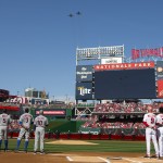 The Washington Nationals and New York Mets watch a flyover before the start of an opening day baseball game at Nationals Park, Monday, April 6, 2015, in Washington. (AP Photo/Evan Vucci)