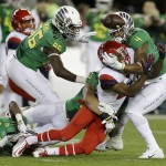 Arizona's Tyrell Johnson (2) fumbles the ball as he is tackled by Oregon's Ifo Ekpre-Olomu (14), Torrodney Prevot (86) and Erick Dargan (4) during the first half of a Pac-12 Conference championship NCAA college football game Friday, Dec. 5, 2014, in Santa Clara, Calif. (AP Photo/Ben Margot)