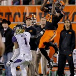 Oklahoma State wide receiver Jhajuan Seales (81) makes a catch as Washington cornerback John Ross (1) defends during the second half of the Cactus Bowl NCAA college football game, Friday, Jan. 2, 2015, in Tempe, Ariz. (AP Photo/Rick Scuteri)