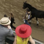Fans watch a race before the 141st running of the Kentucky Derby horse race at Churchill Downs Saturday, May 2, 2015, in Louisville, Ky. (AP Photo/Charlie Riedel)