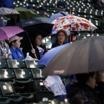  Fans take shelter under umbrellas while it rains before a baseball game between the Chicago Cubs and the Arizona Diamondbacks on Monday, April 21, 2014, in Chicago. (AP Photo/Andrew A. Nelles)