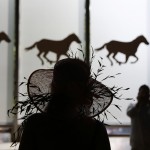  A woman passes silhouettes of race horses at Belmont Park, Saturday, June 7, 2014, in Elmont, N.Y. The Belmont Stakes will be held at the park later in the day. (AP Photo/Matt Slocum)