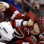 Arizona Coyotes' B.J. Crombeen (44) and New Jersey Devils' Jordin Tootoo (20) fight in the first period of an NHL hockey game Saturday, March 14, 2015, in Glendale, Ariz. (AP Photo/Ross D. Franklin)