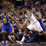 Cleveland Cavaliers forward LeBron James (23) drives on Golden State Warriors forward Harrison Barnes (40) and guard Andre Iguodala (9) during the first half of Game 6 of basketball's NBA Finals in Cleveland, Tuesday, June 16, 2015. (AP Photo/Tony Dejak)
