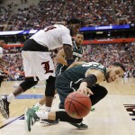 Michigan State's Denzel Valentine (45) reaches for the ball as Louisville's Montrezl Harrell (24) watches during the overtime period in the NCAA men's college basketball tournament Sunday, March 29, 2015, in Syracuse, N.Y. Michigan State won the game 76-70. (AP Photo/Seth Wenig)
