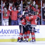 Chicago Blackhawks' Duncan Keith, left, is congratulated by teammates Brandon Saad and Patrick Kane, right, after scoring during the second period in Game 6 of the NHL hockey Stanley Cup Final series on against the Tampa Bay Lightning Monday, June 15, 2015, in Chicago. (AP Photo/Nam Y. Huh)