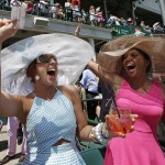 Tiffany Brown, left, Amber Sims celebrate after winning a bet before the 141st running of the Kentucky Oaks horse race at Churchill Downs Friday, May 1, 2015, in Louisville, Ky. (AP Photo/Darron Cummings)