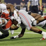 Ohio State's Ezekiel Elliott (15) is tackled during the first half of the NCAA college football playoff championship game against Oregon Monday, Jan. 12, 2015, in Arlington, Texas. (AP Photo/Eric Gay)