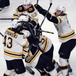 Boston Bruins' Matt Fraser is mobbed by teammates after scoring the game-winning goal during the first overtime period against the Montreal Canadiens in Game 4 in the second round of the NHL Stanley Cup playoffs Thursday, May 8, 2014, in Montreal. (AP Photo/The Canadian Press, Ryan Remiorz)