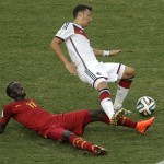 Germany's Mesut Ozil falls over Ghana's Mohammed Rabiu, bottom, following a tackle during the group G World Cup soccer match between Germany and Ghana at the Arena Castelao in Fortaleza, Brazil, Saturday, June 21, 2014. (AP Photo/Themba Hadebe)