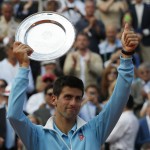 Serbia's Novak Djokovic thumbs up with his trophy after losing the final match of the French Open tennis tournament to Spain's Rafael Nadal at the Roland Garros stadium, in Paris, France, Sunday, June 8, 2014. Nadal won 3-6, 7-5, 6-2, 6-4. (AP Photo/Michel Euler)