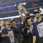 Connecticut head coach Kevin Ollie, center, celebrates with his team after their 60-54 victory over Kentucky in the NCAA Final Four tournament college basketball championship game Monday, April 7, 2014, in Arlington, Texas. (AP Photo/David J. Phillip)